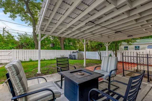 a view of a patio with a table and chairs under an umbrella