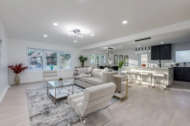 a living room with furniture and a view of kitchen