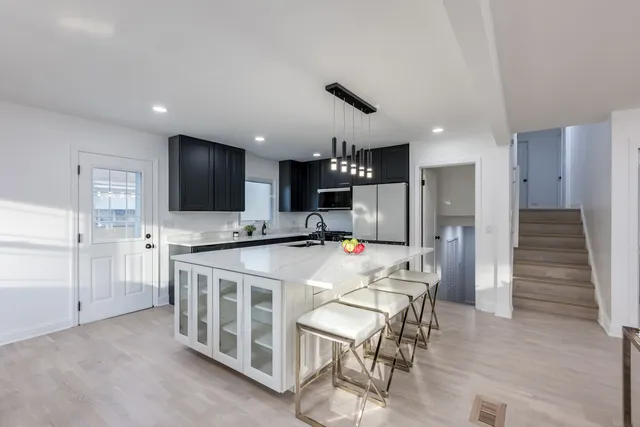 a kitchen that has a lot of cabinets a sink and appliances