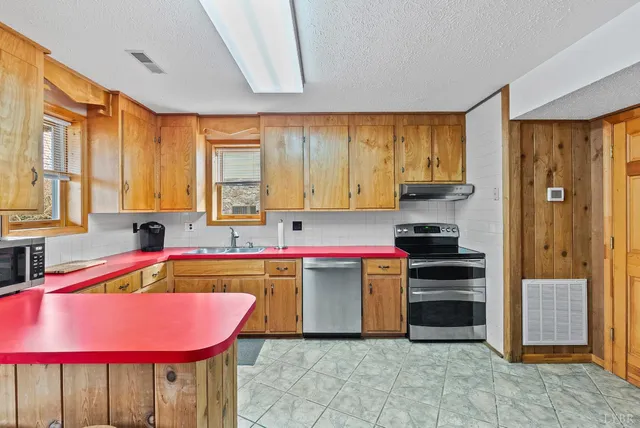 a kitchen with stainless steel appliances granite countertop a sink and cabinets