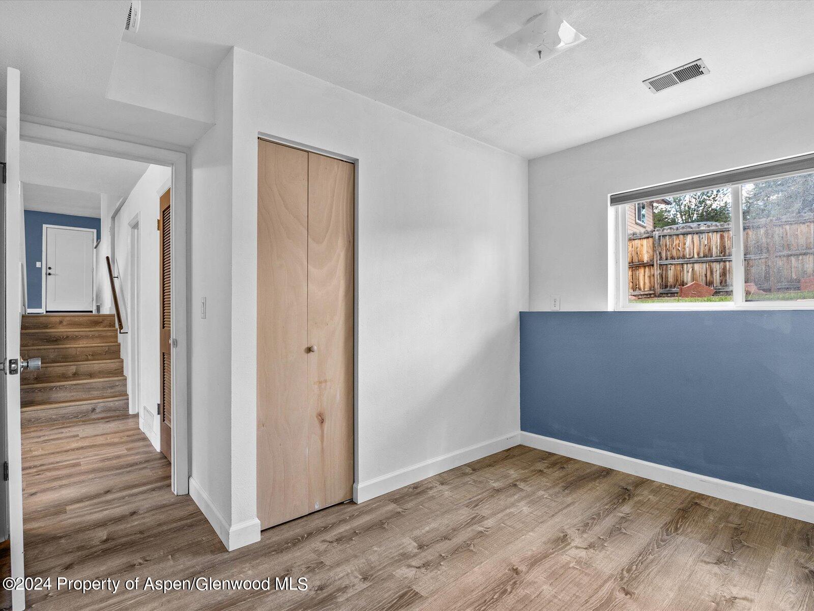 1178 East 8th Street Rifle, CO 81650 - Photo 20 of 28 a view of an empty room with wooden floor and a window