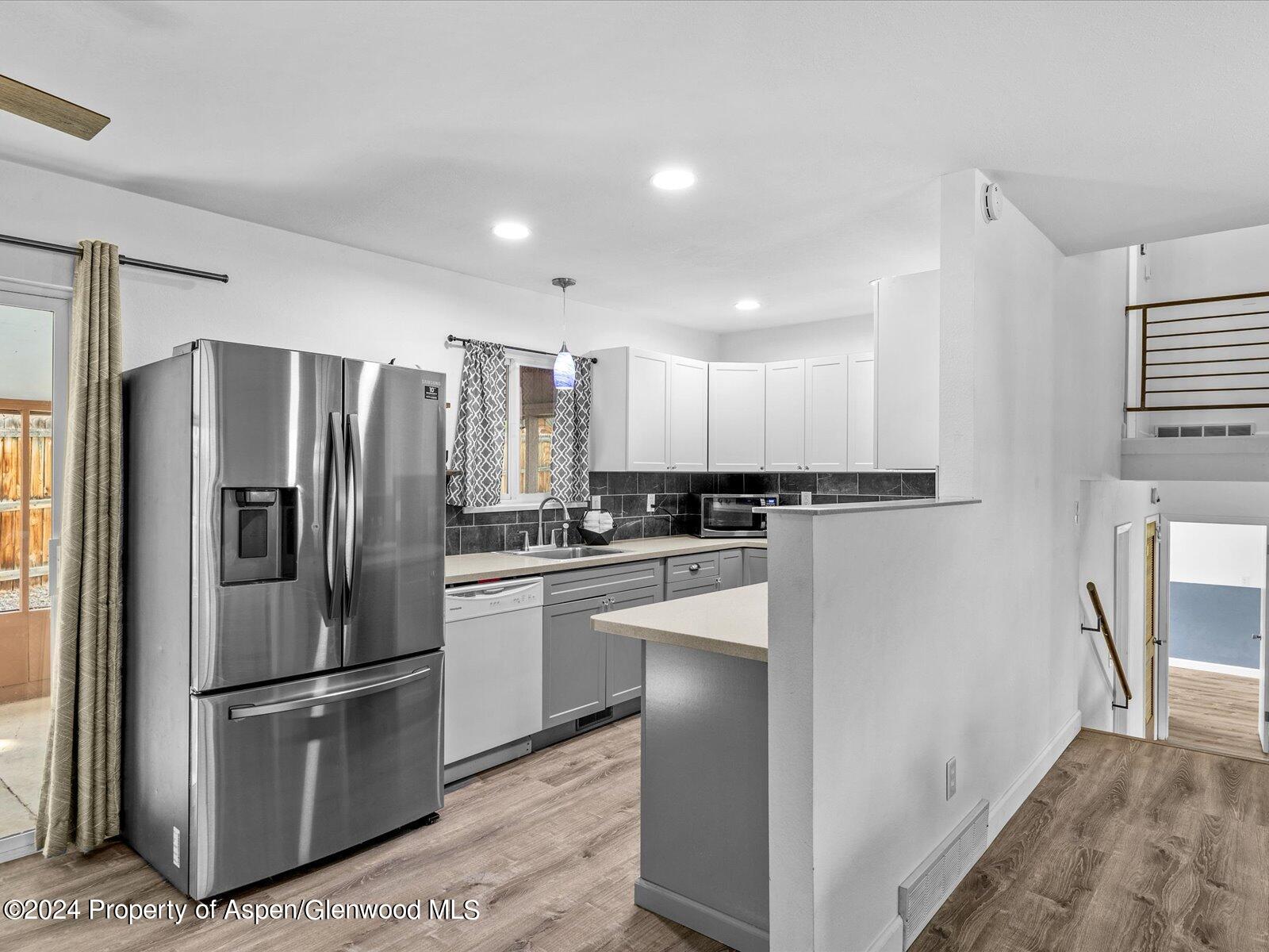1178 East 8th Street Rifle, CO 81650 - Photo 8 of 28 a kitchen with stainless steel appliances granite countertop a refrigerator and a stove
