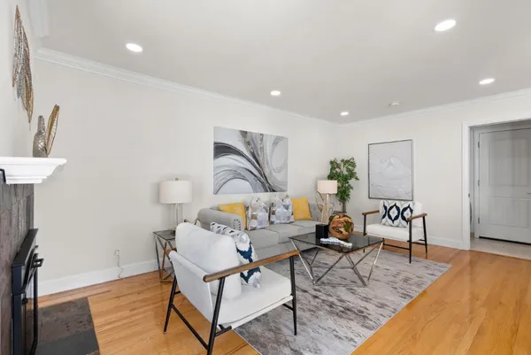 a kitchen with stainless steel appliances kitchen island granite countertop a refrigerator a sink a stove a dining table and chairs with wooden floor