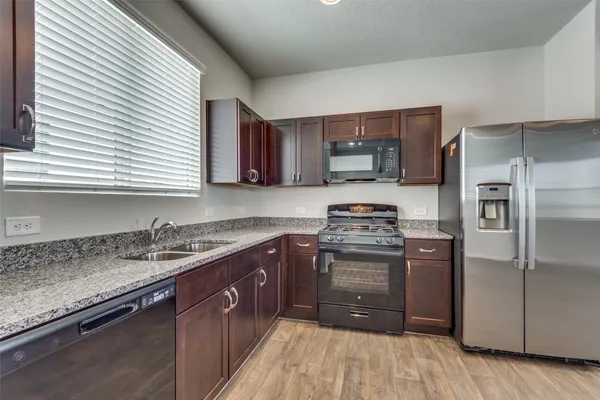 a kitchen with a sink stove and refrigerator