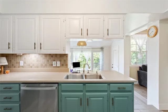 a kitchen with stainless steel appliances granite countertop a sink a stove and white cabinets