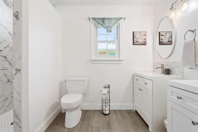 a bathroom with a toilet a sink and a mirror