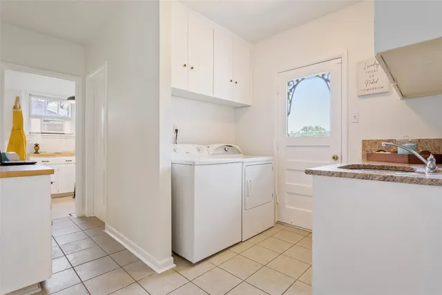 a utility room with cabinets washer and dryer