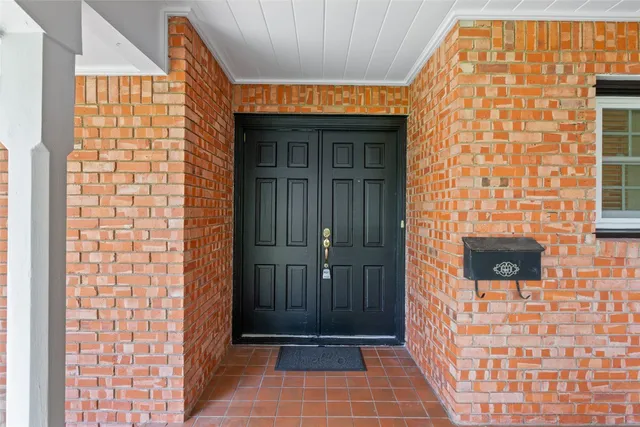 front view of a brick house with a door and a wooden floor
