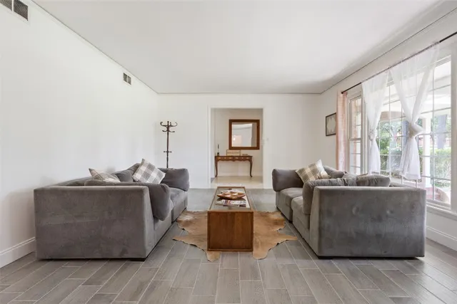 a living room with furniture a wooden floor and a large window
