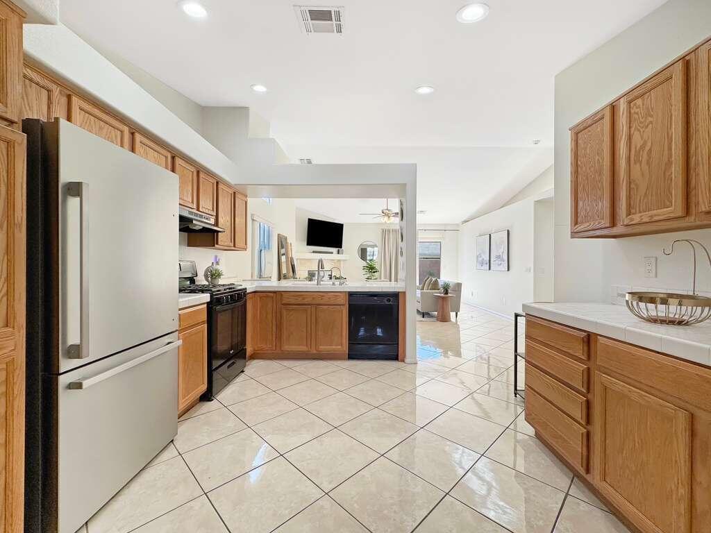 67755 Ontina Road Cathedral City, CA 92234 - Photo 11 of 30 a kitchen with stainless steel appliances a refrigerator sink and cabinets