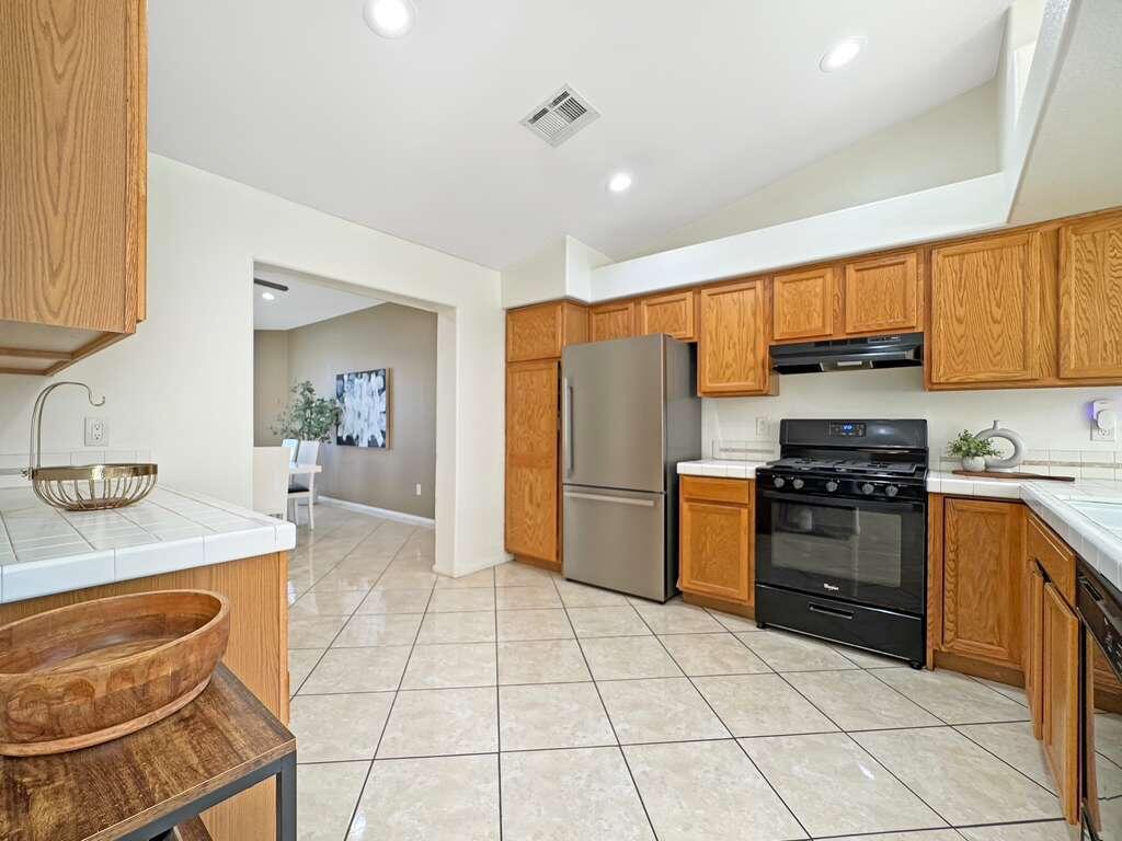 67755 Ontina Road Cathedral City, CA 92234 - Photo 10 of 30 a kitchen with granite countertop a refrigerator and a stove top oven