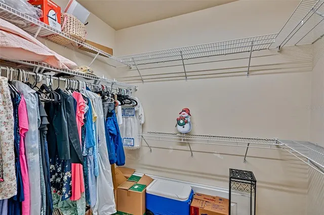 a view of walk in closet with clothes and shoes