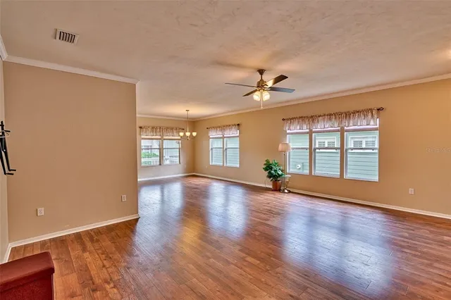 a view of an empty room with window and wooden floor