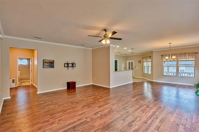a view of an empty room with window and wooden floor