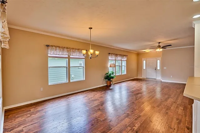 a view of an empty room with window and wooden floor