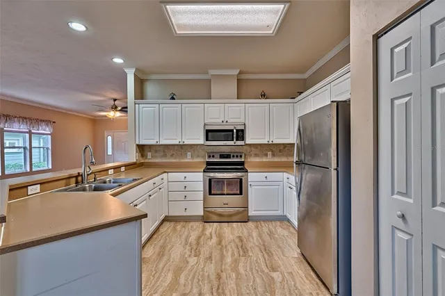 a kitchen with cabinets stainless steel appliances and a window