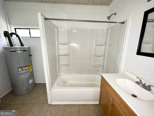 a bathroom with a tub a sink and glass door shower