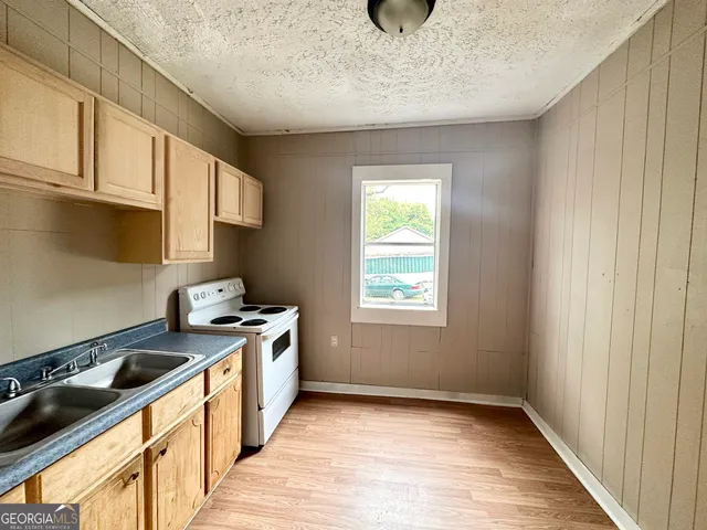 a kitchen with a stove and a wooden floor