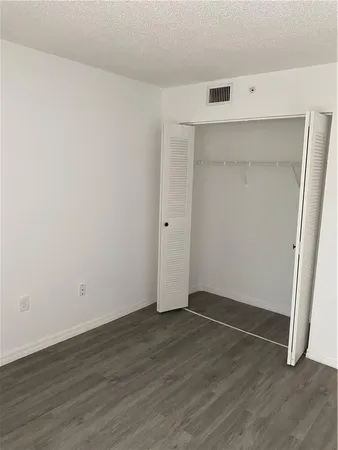 an empty room with wooden floor and white walls