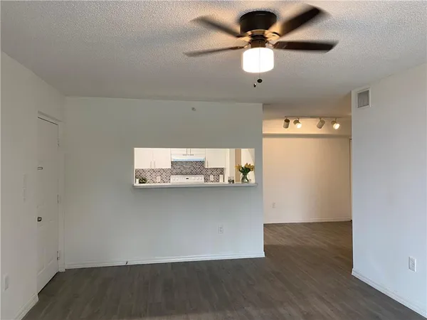 a view of a room with wooden floor and ceiling fan