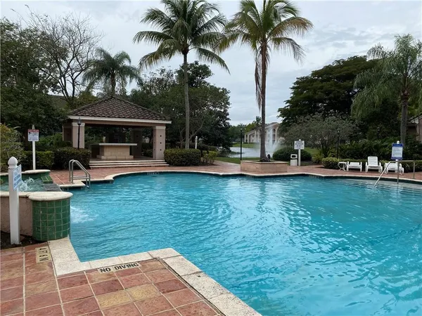 a front view of a house with swimming pool having outdoor seating