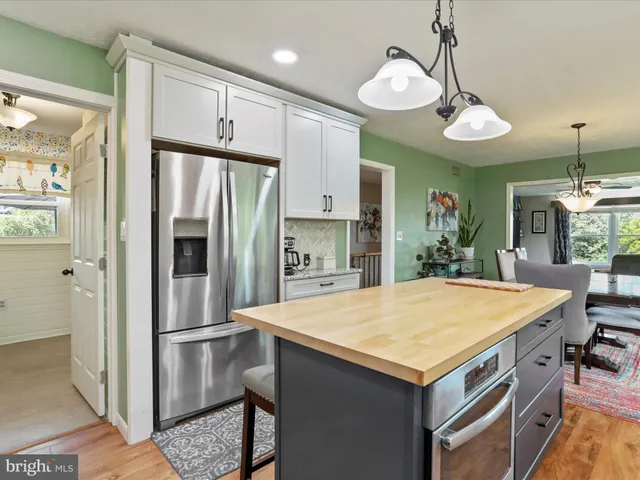 a kitchen with kitchen island a refrigerator a stove a sink dishwasher and wooden cabinets