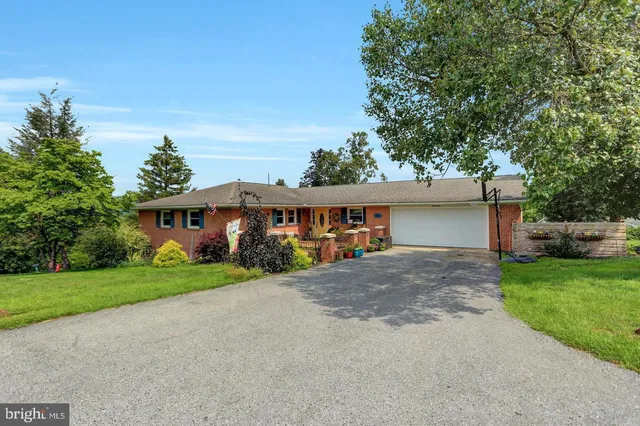 a view of a house with a yard and large tree
