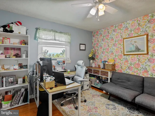 a living room with furniture a bookshelf and a window