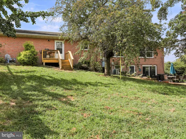 a view of a house with backyard and sitting area