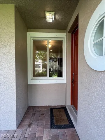 a view of a hallway with wooden floor and a bathroom