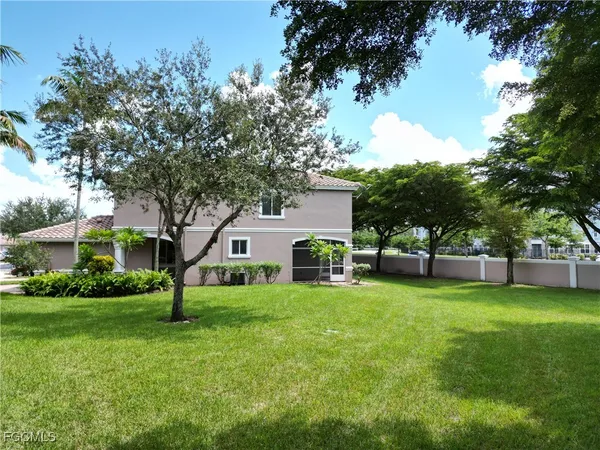 a view of a house with a yard and tree s