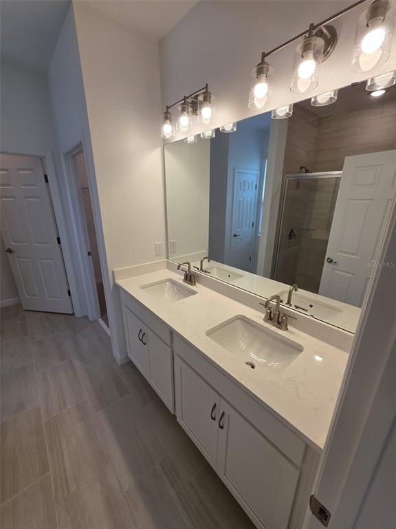 6008 Vision Road St. Cloud, FL 34771 - Photo 23 of 33 a spacious bathroom with double vanity and a mirror