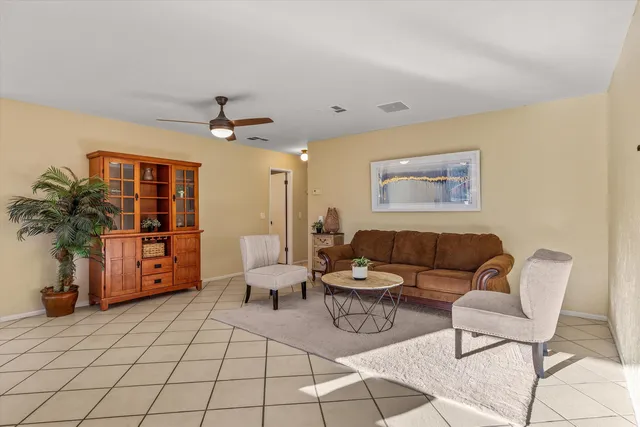 a large white kitchen with granite countertop a sink a counter top space and stainless steel appliances