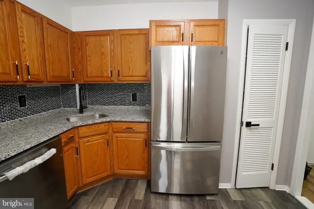 a kitchen with stainless steel appliances granite countertop a refrigerator and a sink