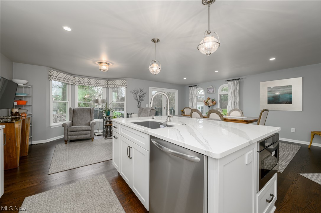 5304 Sibila Road Northwest Canton, OH 44718 - Photo 19 of 29 Kitchen featuring sink, appliances with stainless steel finishes, dark wood-type flooring, decorative light fixtures, and white cabinetry