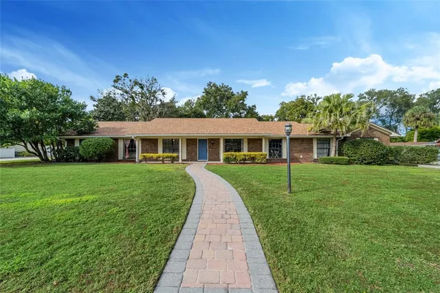 a front view of a house with a yard and trees