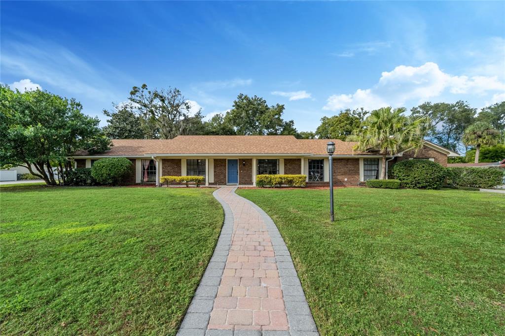 a front view of a house with a yard and trees