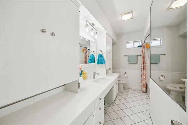 a spacious bathroom with a sink a mirror a toilet and bathtub