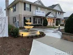 a view of a white house with large windows and a table and chairs in porch