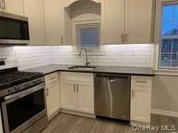 a kitchen with granite countertop cabinets stainless steel appliances and a sink