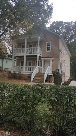 a view of a house with backyard and trees