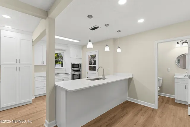 a kitchen with white cabinets and appliances