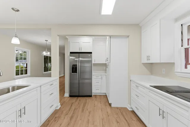a kitchen with a refrigerator sink and cabinets