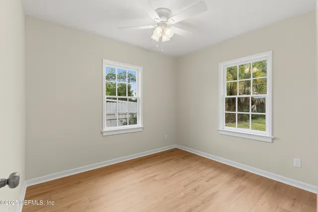 a view of an empty room with wooden floor