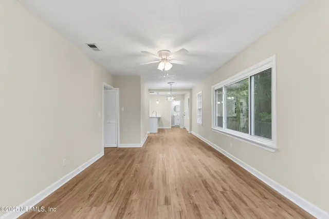 a view of a hallway with wooden floor and a chandelier