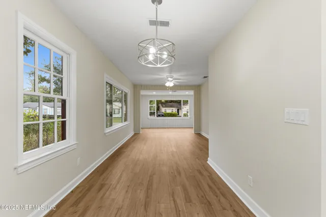 a large kitchen with granite countertop a large kitchen island and a sink dishwasher refrigerator with wooden floor