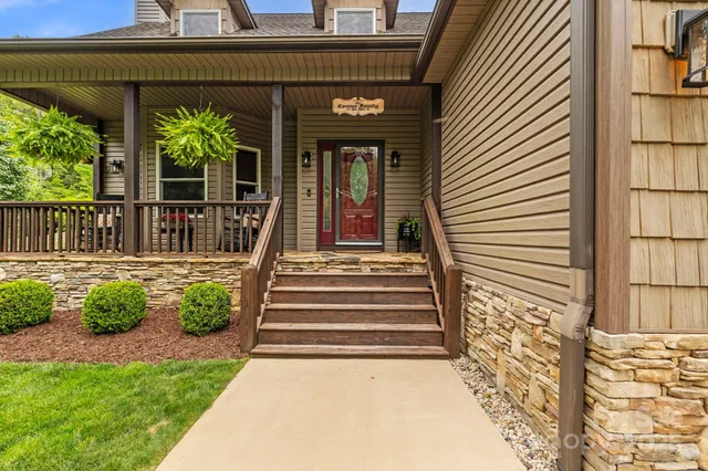 a view of a house with a large window and flower plants