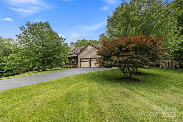 a view of a house with a big yard plants and large trees