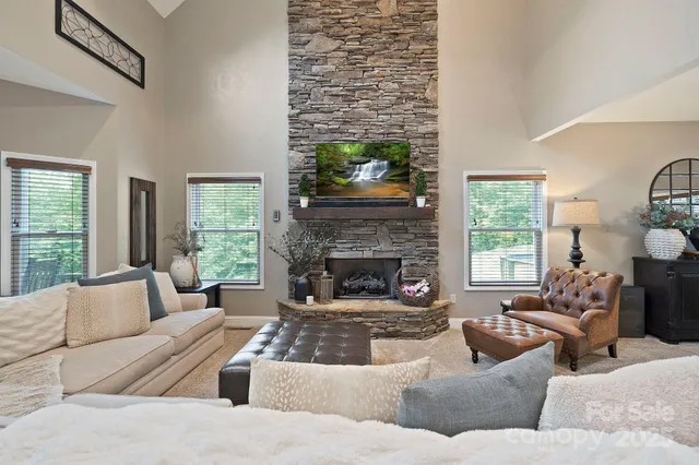 a living room with furniture large window and fireplace