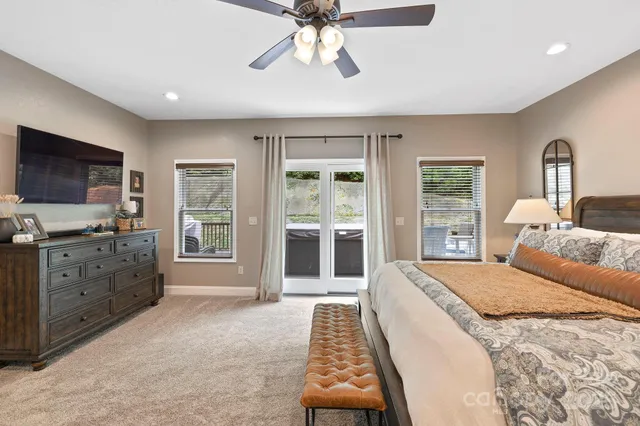 a spacious bedroom with a large bed and a flat tv screen on dresser